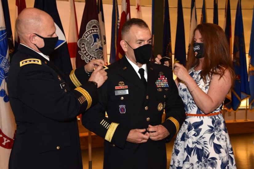 Army Medical Logistics Command Commander Brig. Gen. Michael Lalor, center, receives his one-star shoulder boards from Army Materiel Command Commanding Gen. Ed Daly, left, and his wife, Michelle, during a promotion ceremony at Fort Detrick, Maryland, on Sept. 11. (Photo Credit: Ellen Crown)