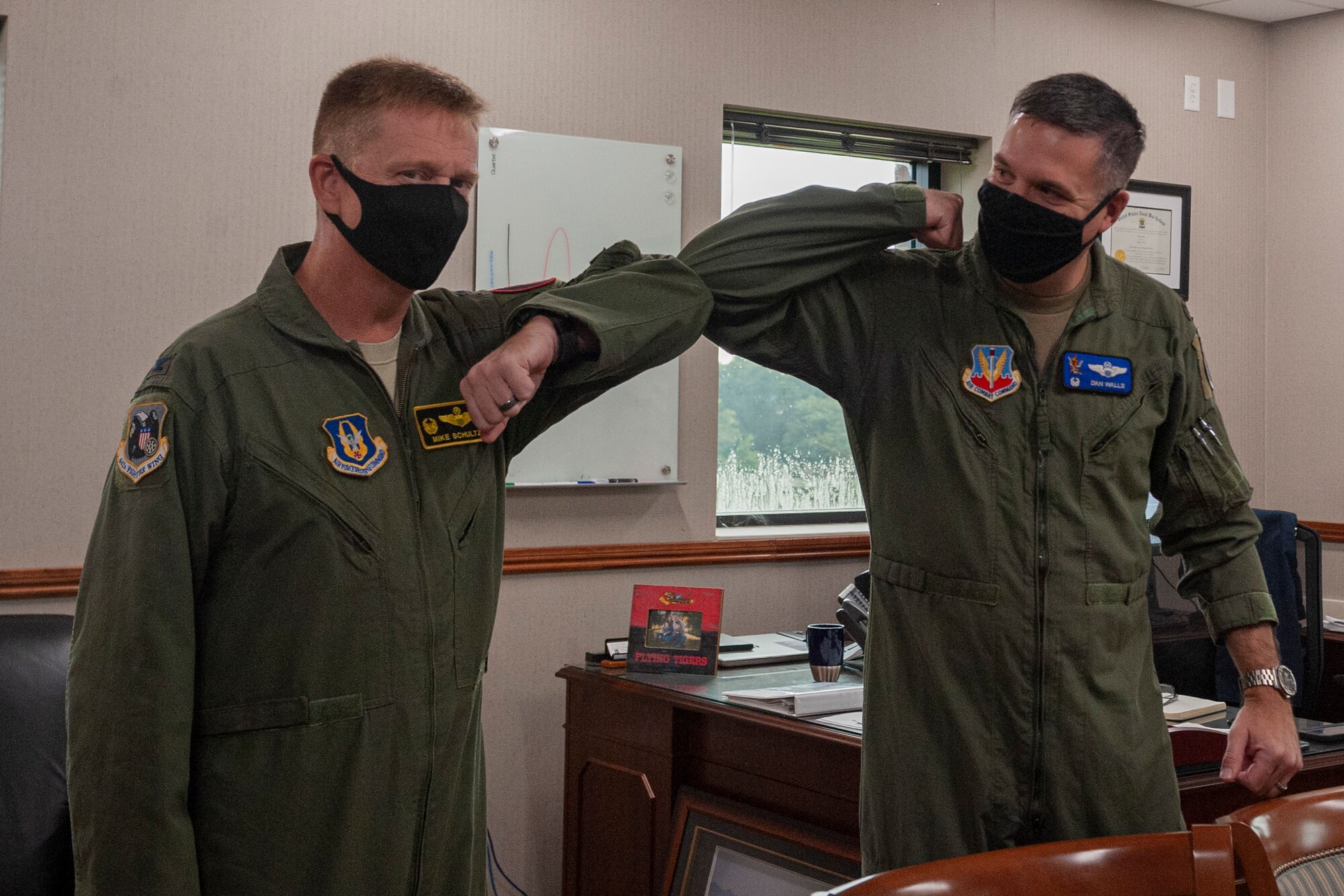 Photo of Col. Schultz and Col. Walls bumping elbows