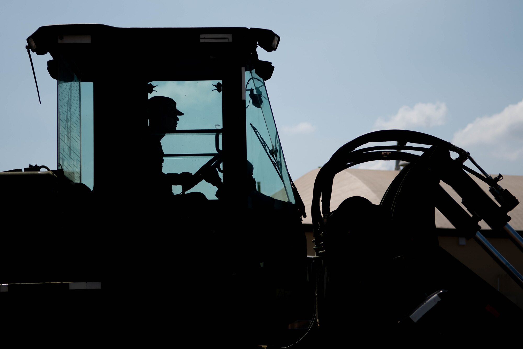 silhouette of man driving heavy machinery