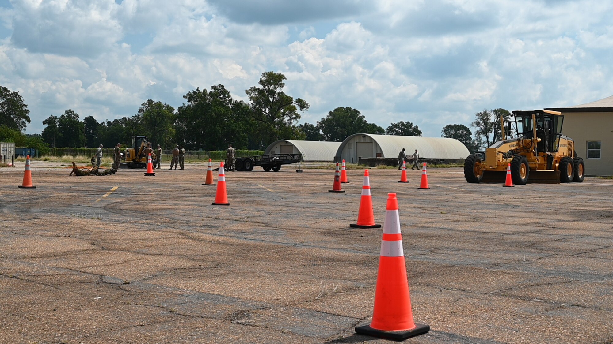 Airmen break into groups around heavy equipment