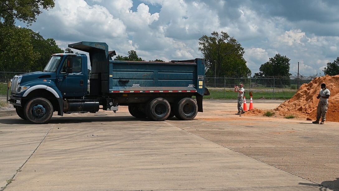 Airman directs operator of vehicle backing up