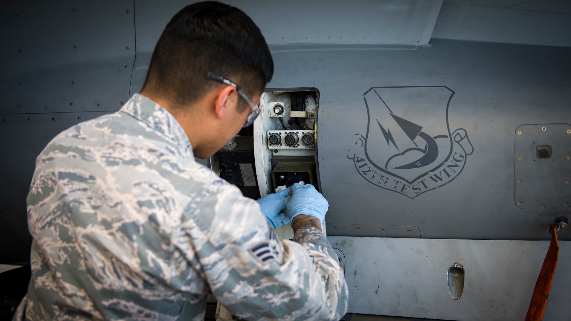 Senior Airman Nathan Nauta, electrical and environmental technician assigned to the 926th Maintenance Support Squadron, Nellis Air Force Base, Nevada, conducts maintenance services on a communications terminal on an F-16 Fighting Falcon at Edwards Air Force Base, California, July 24. (Air Force photo by Giancarlo Casem)