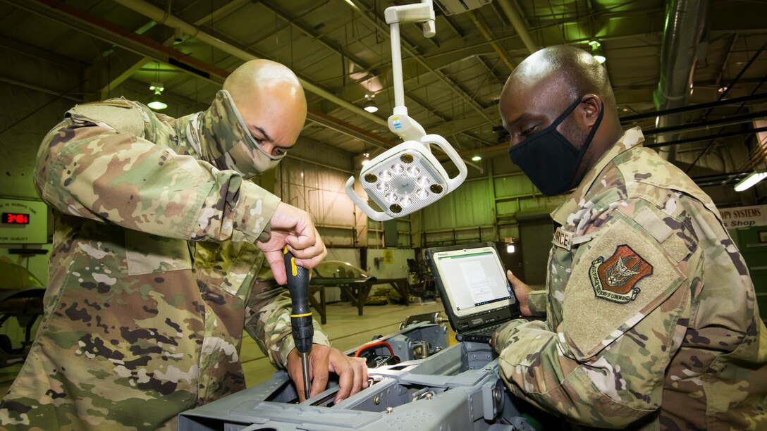 Aircrew egress specialist Senior Airman Alberto Rory, 482nd Fighter Wing, Homestead Air Force Base, Florida, and Senior Airman Bethenokelm Volcy, conduct maintenance on an ejection seat at Edwards Air Force Base, California, July 24. (Air Force photo by Giancarlo Casem)