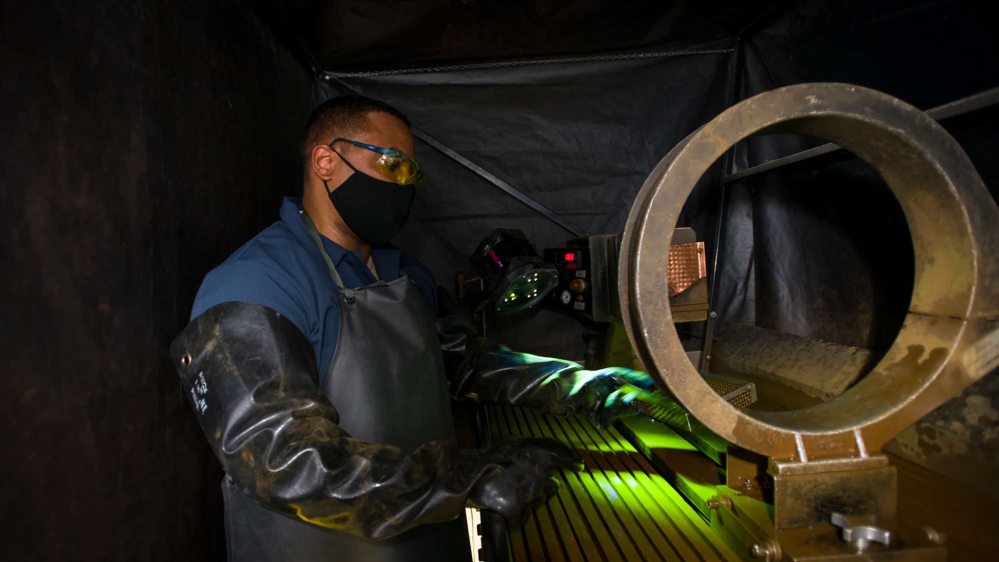 Tech. Sgt. Corey Nichols, a non-destructive inspection technician with the 177th Fighter Wing, Atlantic City International Airport, New Jersey, inspects aircraft parts utilizing a UV light at Edwards Air Force Base, California, July 24. (Air Force photo by Giancarlo Casem)