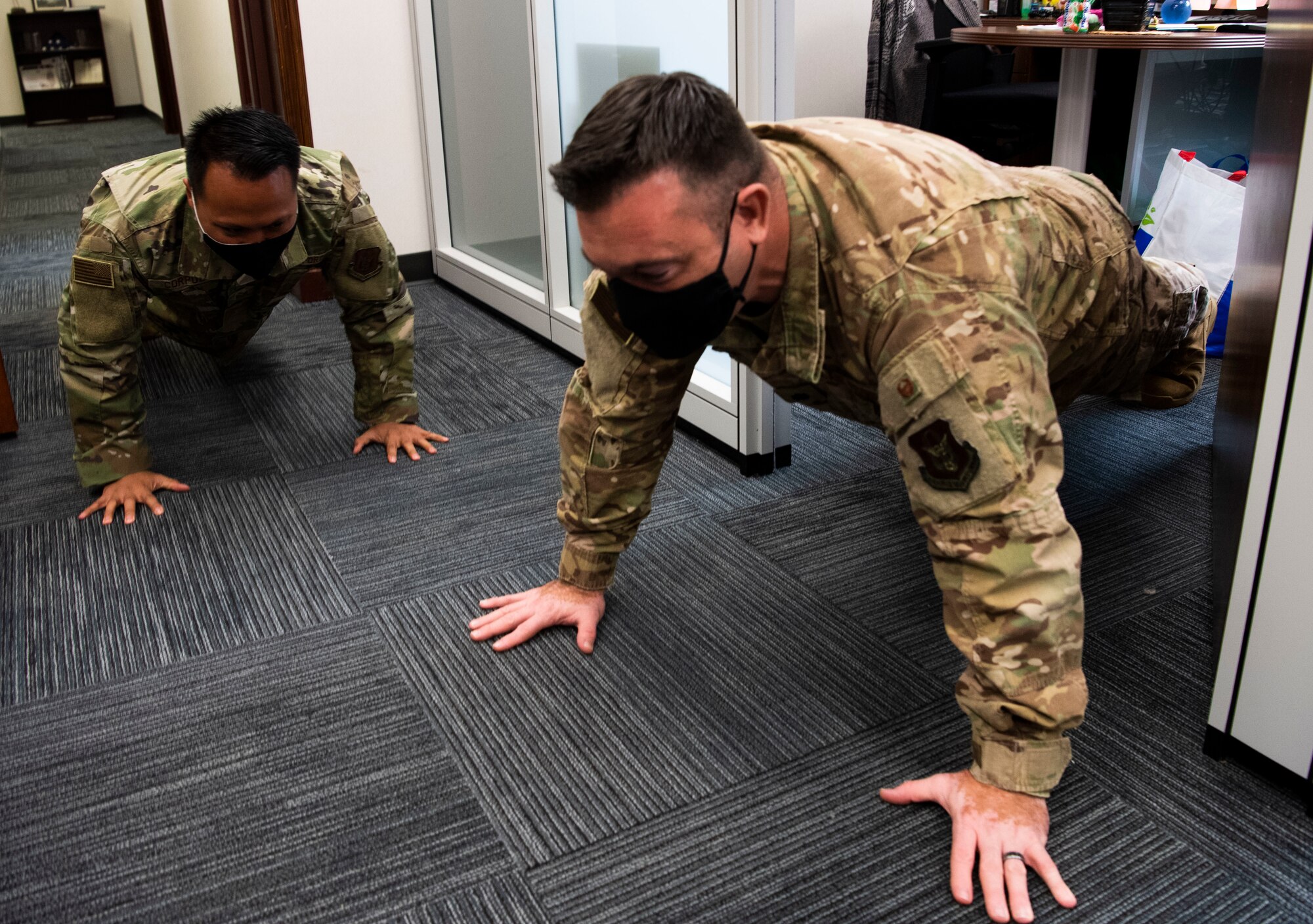 A photo of U.S. Air Force Staff Sgt. Mark Corpuz and Lt. Col. Cliff Harris, both who are part of the 624th Regional Support Group command staff, doing push-ups as part of a Resiliency Tactical Pause at Joint Base Pearl Harbor-Hickam, Hawaii, Sept. 12, 2020, during the Group's Unit Training Assembly.