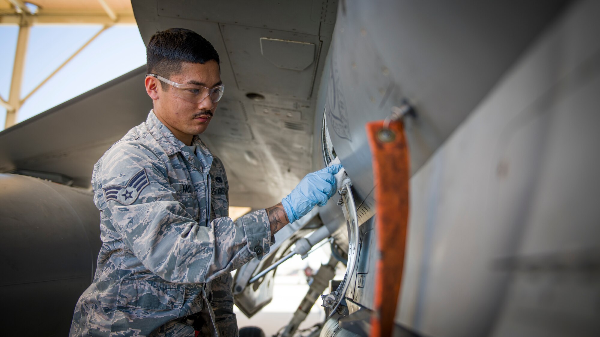 Senior Airman Nathan Nauta, electrical and environmental technician assigned to the 926th Maintenance Support Squadron, Nellis Air Force Base, Nevada, conducts maintenance services on a communications terminal on an F-16 Fighting Falcon at Edwards Air Force Base, California, July 24. (Air Force photo by Giancarlo Casem)