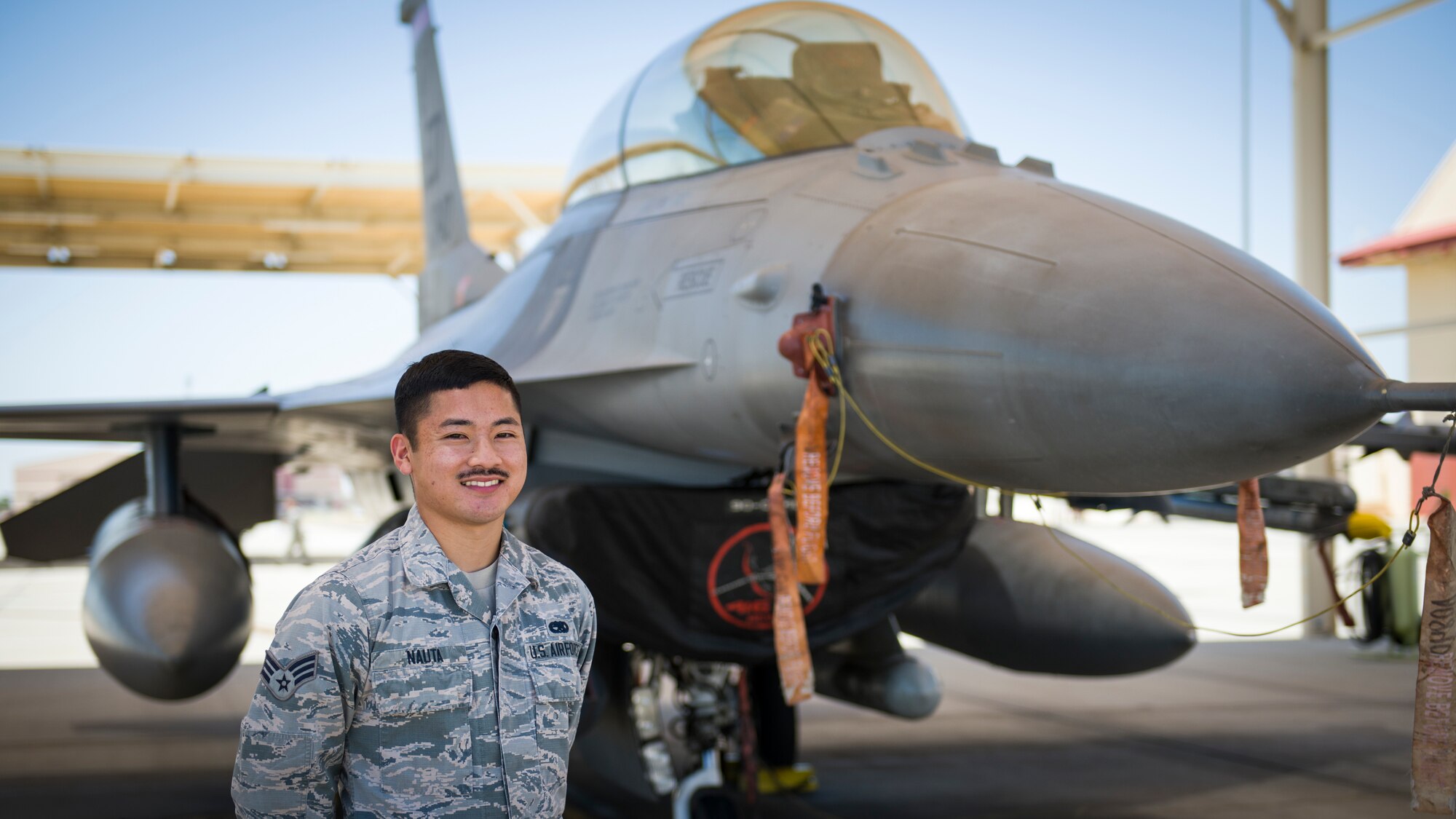 Senior Airman Nathan Nauta, electrical and environmental technician assigned to the 926th Maintenance Support Squadron, Nellis Air Force Base, Nevada, poses for a photo in front of an F-16 Fighting Falcon at Edwards Air Force Base, California, July 24. (Air Force photo by Giancarlo Casem)
