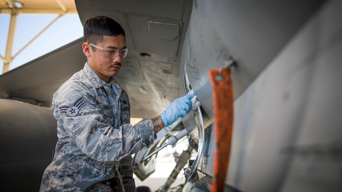Tech. Sgt. Corey Nichols, a non-destructive inspection technician with the 177th Fighter Wing, Atlantic City International Airport, New Jersey, inspects aircraft parts utilizing a UV light at Edwards Air Force Base, California, July 24. (Air Force photo by Giancarlo Casem)