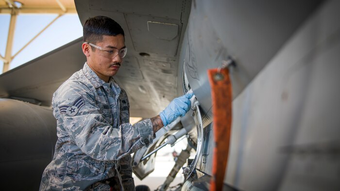 Senior Airman Nathan Nauta, electrical and environmental technician assigned to the 926th Maintenance Support Squadron, Nellis Air Force Base, Nevada, conducts maintenance services on a communications terminal on an F-16 Fighting Falcon at Edwards Air Force Base, California, July 24. (Air Force photo by Giancarlo Casem)