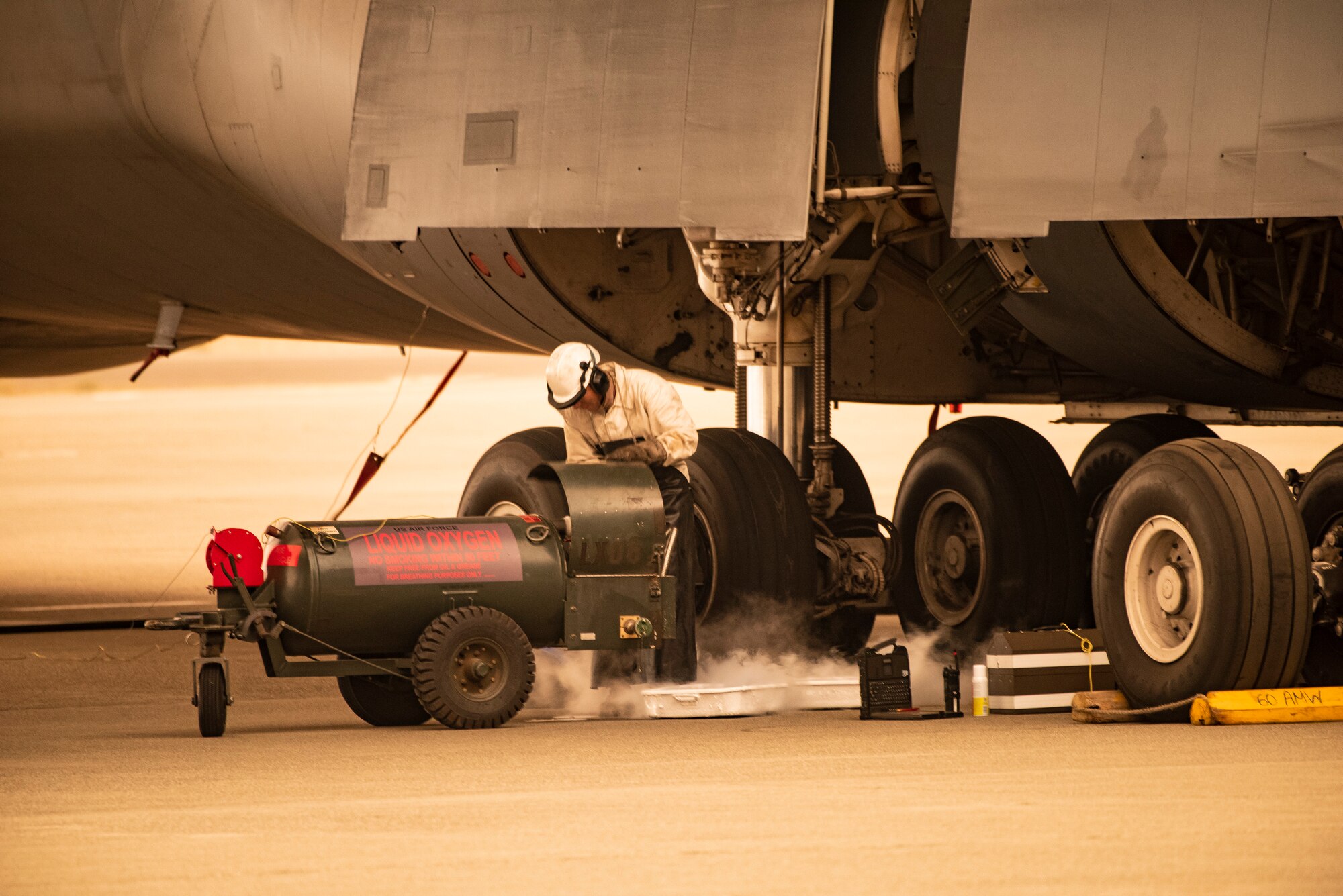 U.S. Air Force Airman 1st Class Ricardo Puente, 60th Aircraft Maintenance Squadron crew chief, services the oxygen system of a C-5M Super Galaxy Sept. 9, 2020 at Travis Air Force Base, California. Wildfires across California propelled smoke and ash into the troposphere, impacting air quality. (U.S. Air Force photo by Heide Couch)