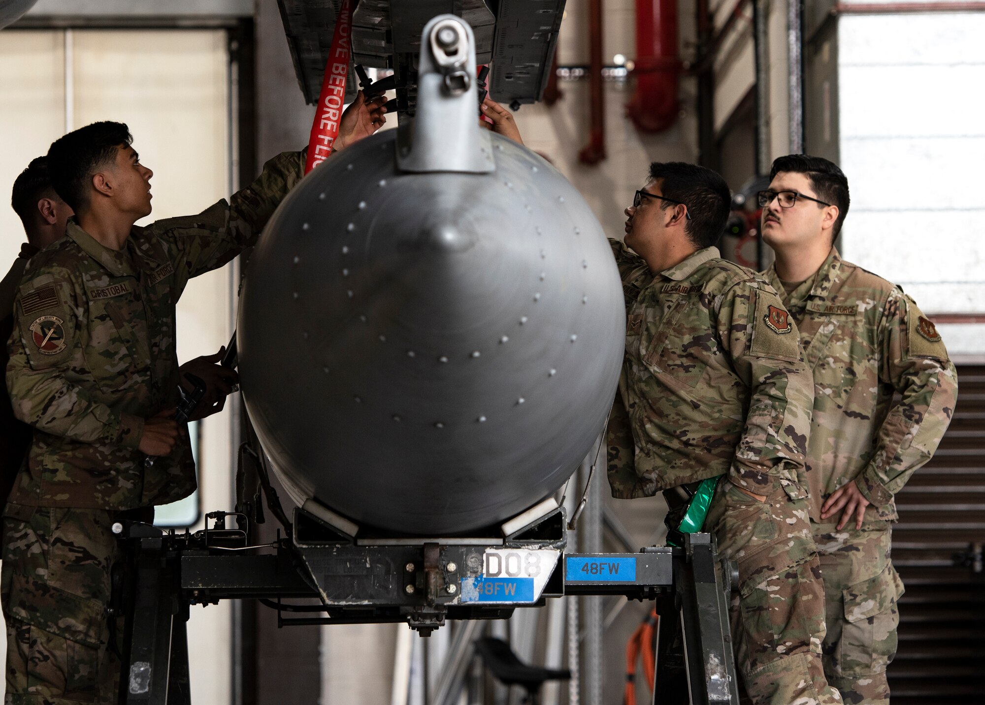 U.S. Air Force Airmen, assigned to the 48th Component Maintenance Squadron fuels systems maintenance shop, learn how to attach an external fuel tank to an F-15C Eagle during an Agile Combat Employment training at Royal Air Force Lakenheath, England, Aug. 31, 2020. Proficiency in a multitude of skills allows Airmen to more effectively and efficiently respond to unique scenarios and potential threats, which is a key aspect of the ACE initiative. (U.S. Air Force photo by Airman 1st Class Jessi Monte)