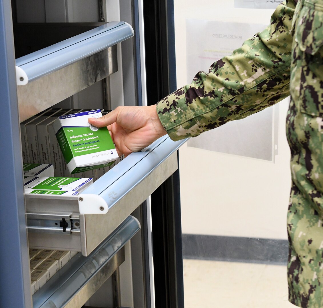 A Navy Medicine Readiness and Training Command Sailor opens vaccination refrigerator to examine southern hemisphere flu vaccine at Shipyard Clinic Immunizations Department at Naval Health Clinic Hawaii Sept. 14, 2020.