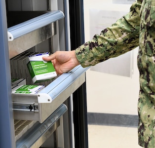 A Navy Medicine Readiness and Training Command Sailor opens vaccination refrigerator to examine southern hemisphere flu vaccine at Shipyard Clinic Immunizations Department at Naval Health Clinic Hawaii Sept. 14, 2020.