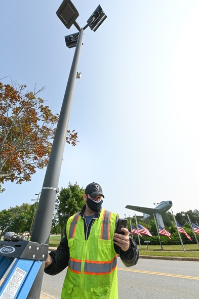 Alan Blackington, traffic data analyst for Accurate Counts of North Reading, Mass., checks a traffic monitoring camera transmission by his phone at Hanscom Air Force Base, Mass., Sept. 15. The cameras will allow 66th Civil Engineering Division officials to perform an environmental impact assessment of traffic across the installation. (U.S. Air Force photo by Todd Maki)