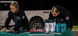 Capt. Nicole McCoy, sexual harassment/assault response and prevention program manager, 1st Theater Sustainment Command, and Master Sgt. Nicole Schmidt, sexual assault response coordinator, 1st TSC, prepare a gift table for the Dedicate Your Run/Walk event on Sept. 10, 2020 at Fort Knox, Kentucky. The event took place to raise awareness for the more than 7825 survivors of sexual assault and harassment across the Department of Defense.