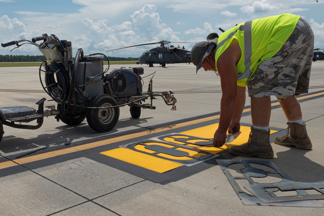 Photo of a contractor placing a stencil over a parking sign