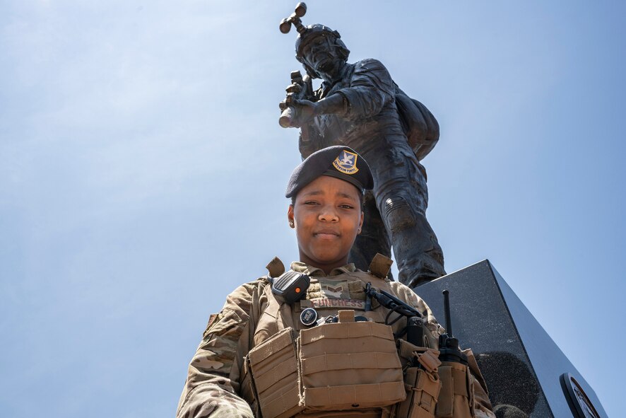 Photo of Airman standing in front of a memorial