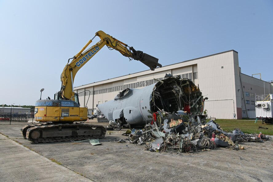 A contractor uses an excavator to remove a static C-130 trainer near the flight line at Hanscom Air Force Base, Mass., Sept. 15. The aircraft, which has been here since October 1982, was used for training by aerial port squadrons and the fire department during base exercises. (U.S. Air Force photo by Todd Maki)