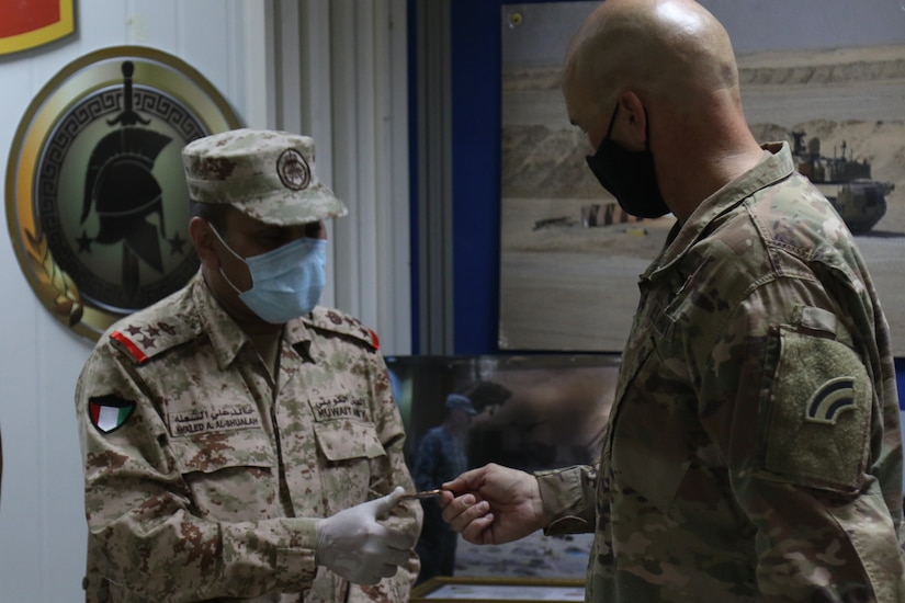 Kuwait military Brig. Gen. Khaled Al-Shualah is presented with a division coin from Brig. Gen. Thomas Spencer the 42nd Infantry Division Deputy Commander for Support on September 10, 2020 in Kuwait. The Two country have been working together to strengthen their partnership. (U.S. Army Photo by Sgt. Andrew Winchell)