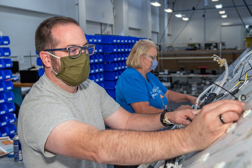 Photo of William Laury Carol Rewick buildingthe main dash harness.