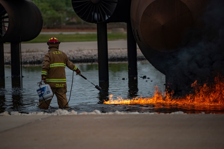 Christopher Craig, 7th Civil Engineer Squadron lead firefighter, ignites gasses surrounding an aircraft fire trainer at Dyess Air Force Base, Texas, Sept. 15, 2020. During the aircraft fire training, 7th CES Airmen implemented their firefighting knowledge and abilities while testing and familiarizing themselves with their equipment. (U.S. Air Force photo by Airman 1st Class Colin Hollowell)