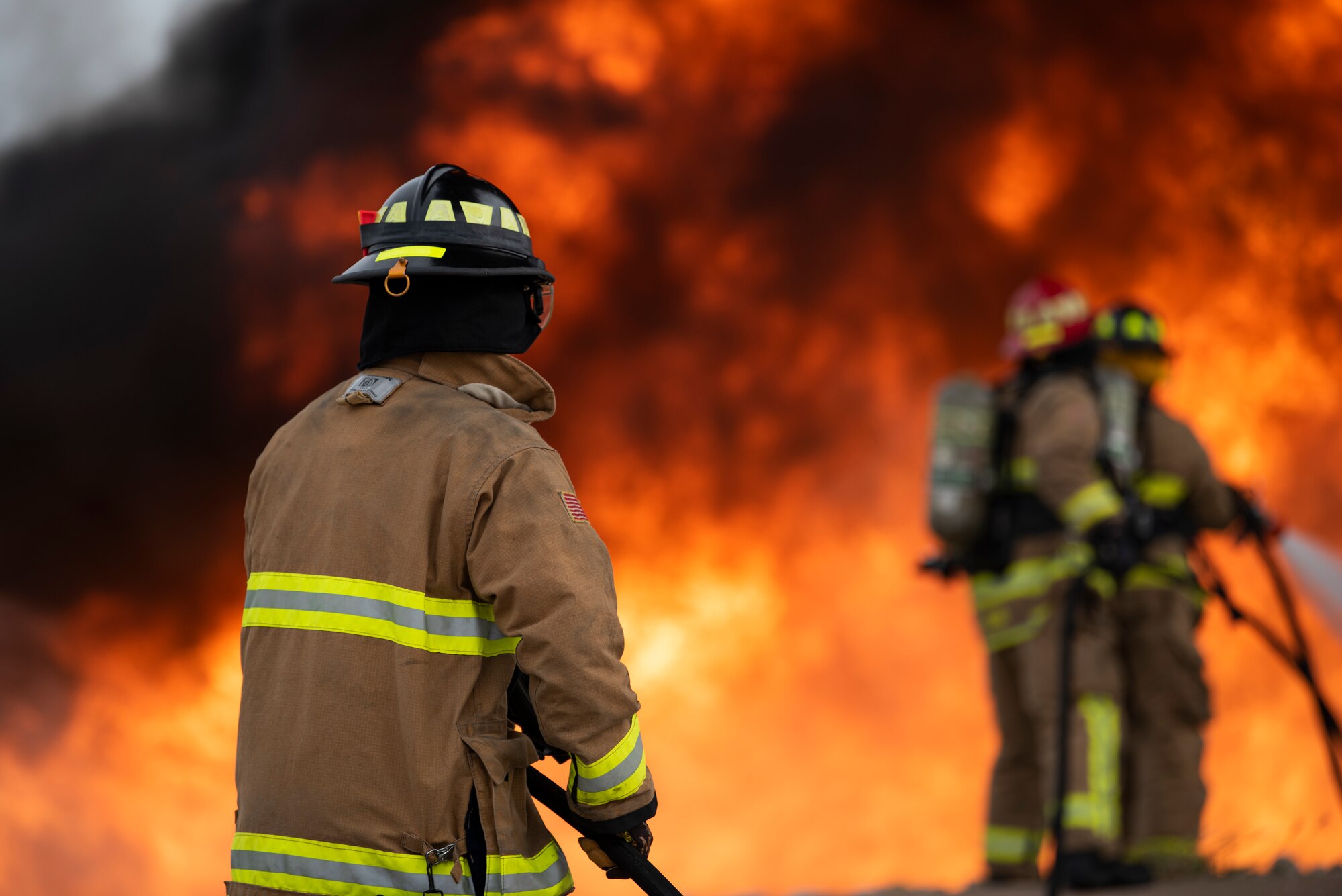 Senior Airman Thomas Drouillard, 445th Civil Engineer Squadron firefighter, assists with holding a fire hose being used to extinguish a fire on an aircraft fire trainer at Dyess Air Force Base, Texas, Sept. 15, 2020. Although ultra-high pressure firefighting is not a new idea, new technology provides firefighters the ability to use the method in events that benefit more from the upgraded fire suppression system. (U.S. Air Force photo by Airman 1st Class Colin Hollowell)