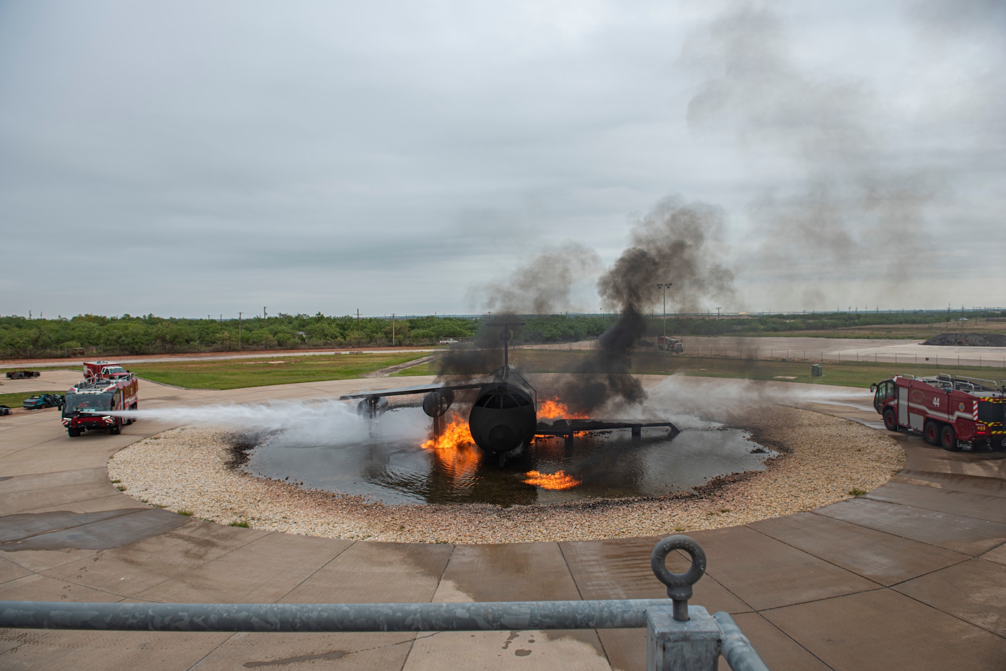 Two 7th Civil Engineer Squadron Rosenbauer Panther fire trucks extinguish a fire on an aircraft fire trainer at Dyess Air Force Base, Texas, Sept. 15, 2020. The Rosenbauer Panther fire truck is an aircraft rescue and firefighting vehicle that specializes in emergency response and passenger rescue during aircraft fires and emergencies. (U.S. Air Force photo by Airman 1st Class Colin Hollowell)