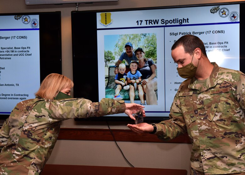 U.S. Air Force Chief Master Sgt. Casy Boomershine, 17th Training Wing command chief, coins Staff Sgt. Patrick Berger, 17th Contracting Squadron contract specialist, at the Wing Standup in the Norma Brown building on Goodfellow Air Force Base, Texas, Sept. 15, 2020. Berger was recognized as one of the top Airmen of Goodfellow in front of base leadership. (U.S. Air Force photo by Staff Sgt. Seraiah Wolf)