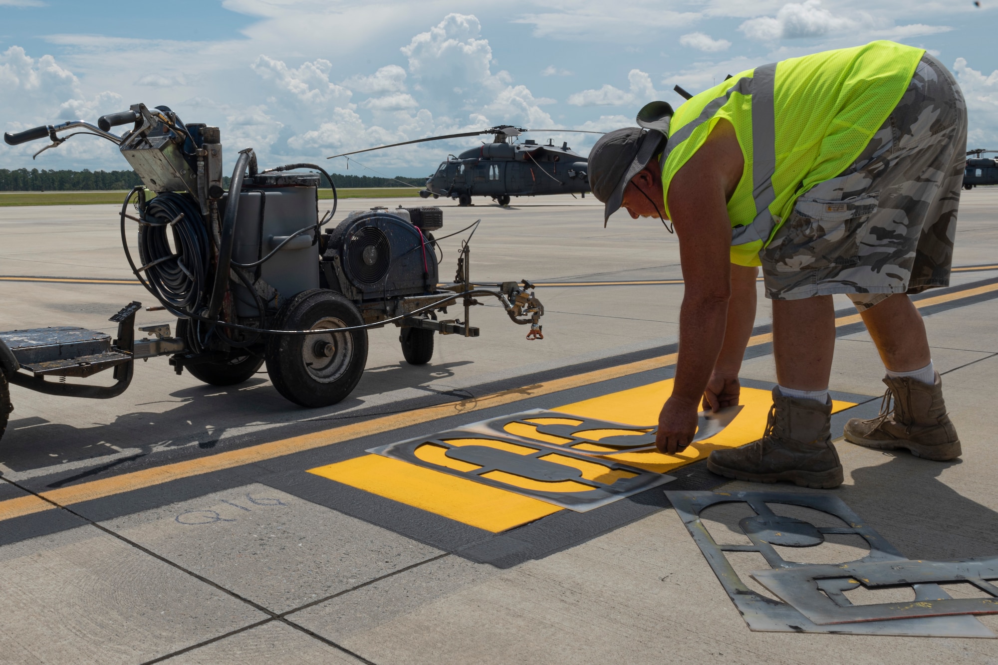 Photo of a contractor placing a stencil over a parking sign