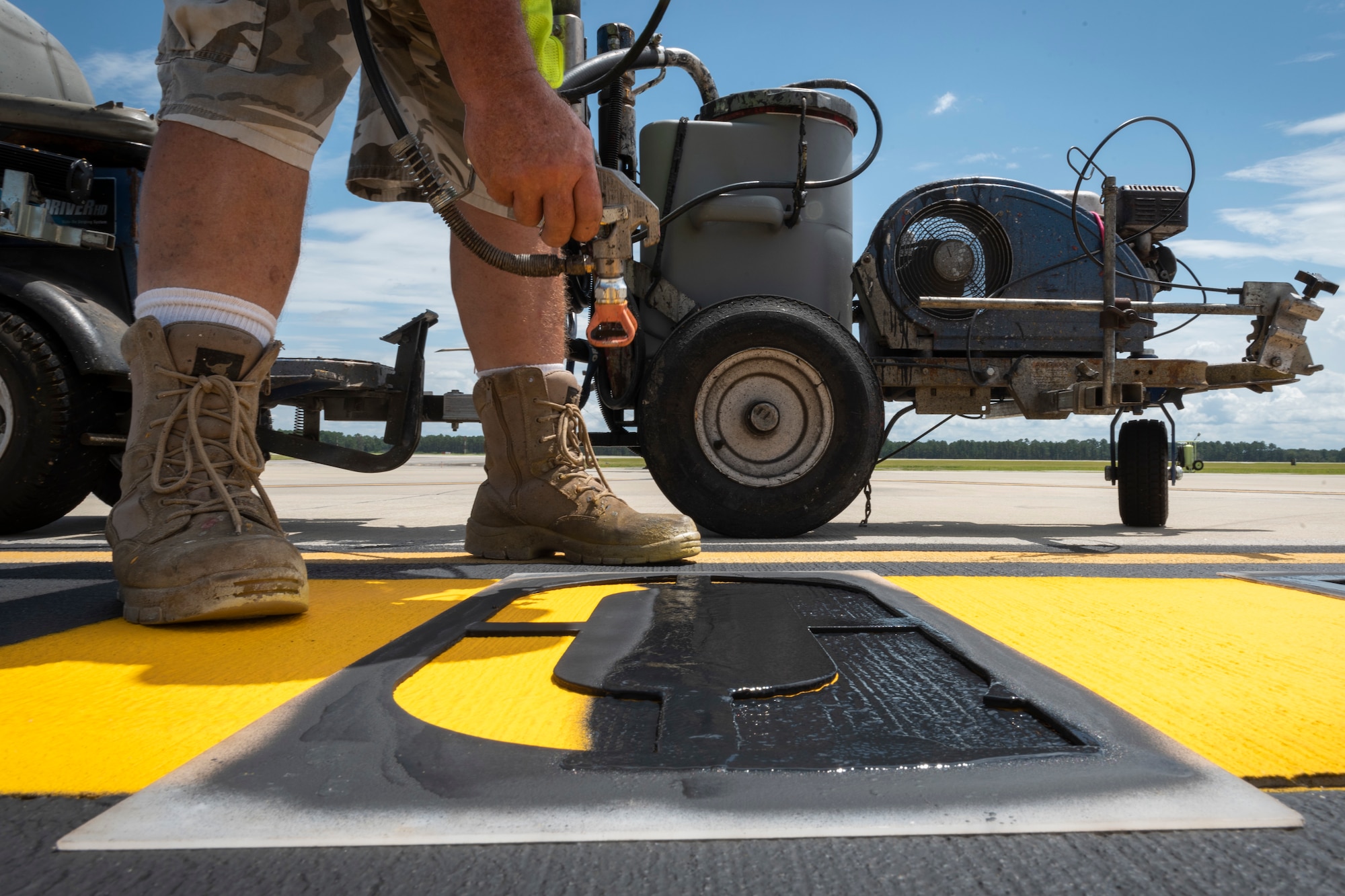 Photo of a contractor painting a designated parking sign