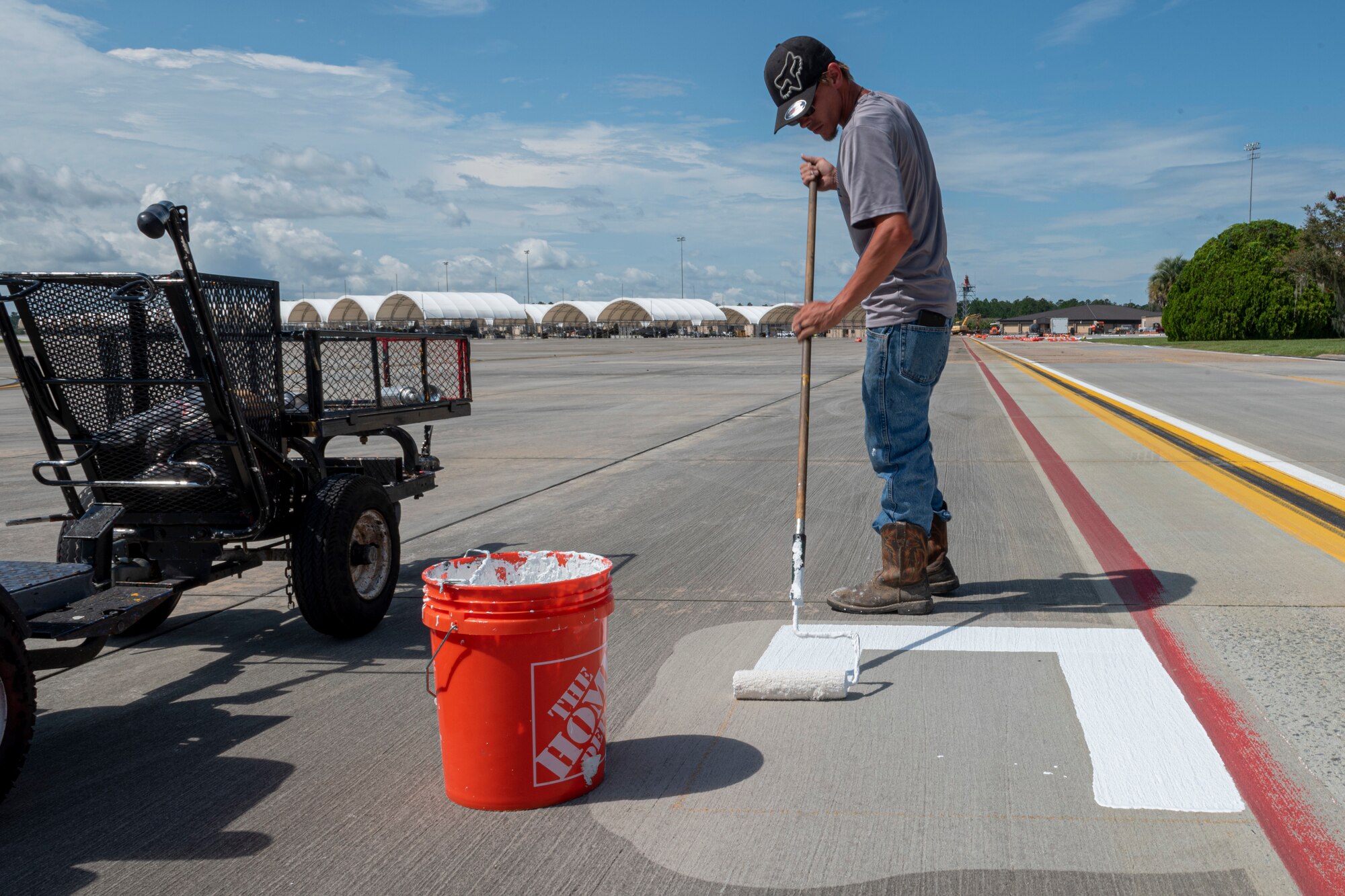 Photo of a contractor painting a base layer for a sign