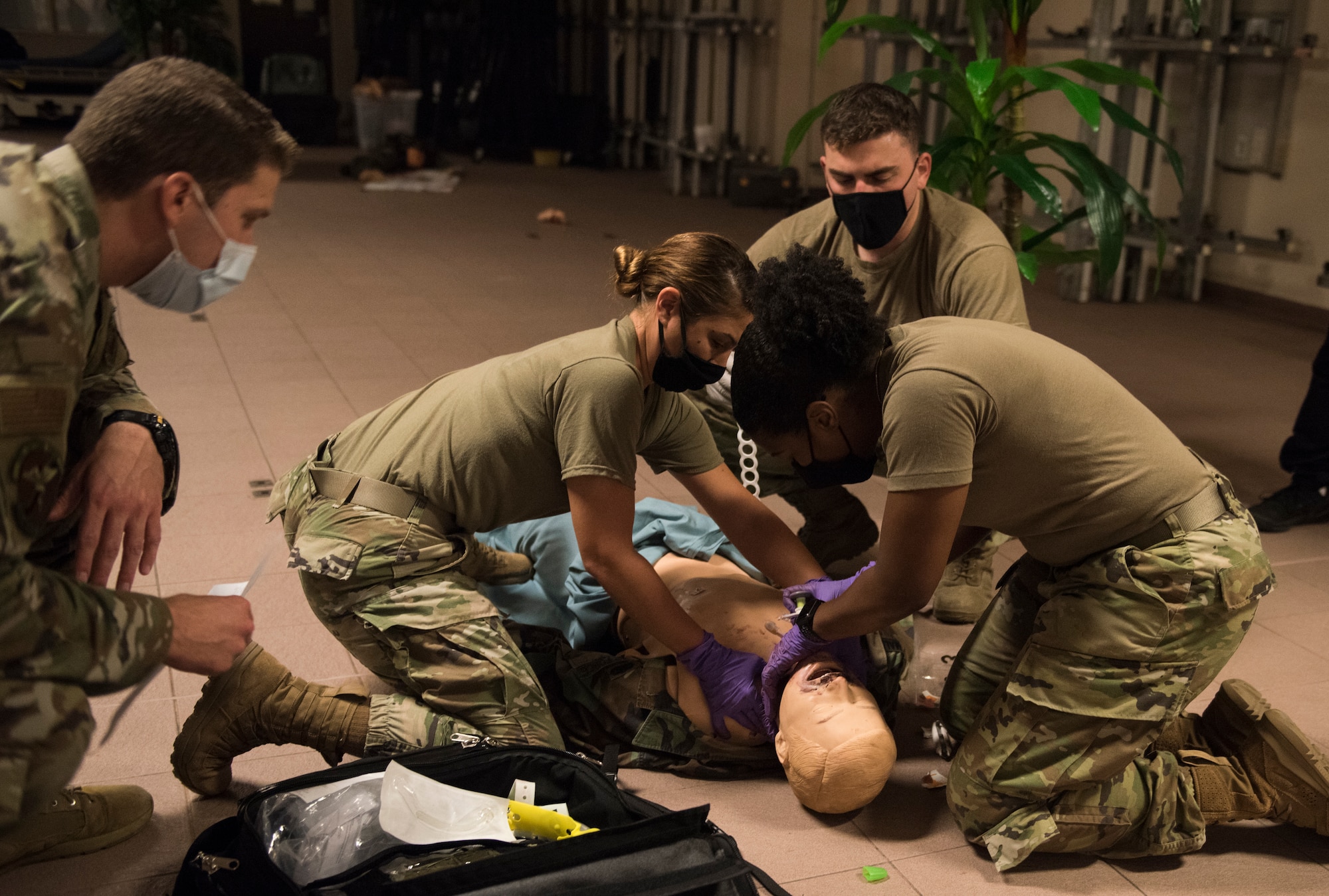 4 medical personnel performing medical treatment on plastic dummy