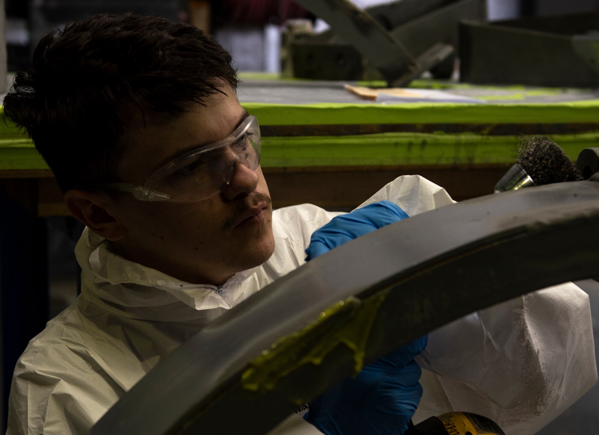 Senior Airman Tristan Casner, 48th Equipment Maintenance Squadron Fabrication Flight, uses a rotating wire brush to remove signs of corrosion from an aircraft component at Royal Air Force Lakenheath, England, Sept. 15, 2020. The Fabrication Flight maintains the structural integrity of aircraft using specialized tools and equipment to repair damage and fabricate replacement parts, ensuring the 48th Fighter Wing remains a ready and capable force. (U.S. Air Force photo by Airman 1st Class Jessi Monte)