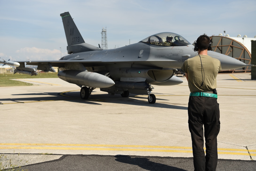 Senior Airman Cole McGriff, 555th Fighter Squadron crew chief, marshals a U.S. Air Force F-16 Fighting Falcon during exercise Point Blank 20-4 at Aviano Air Base, Italy, Sept. 10, 2020. Point Blank is a recurring, low-cost exercise initiative designed to increase the tactical proficiency of multiple forces. (U.S. Air Force photo by Staff Sgt. Heidi Goodsell)