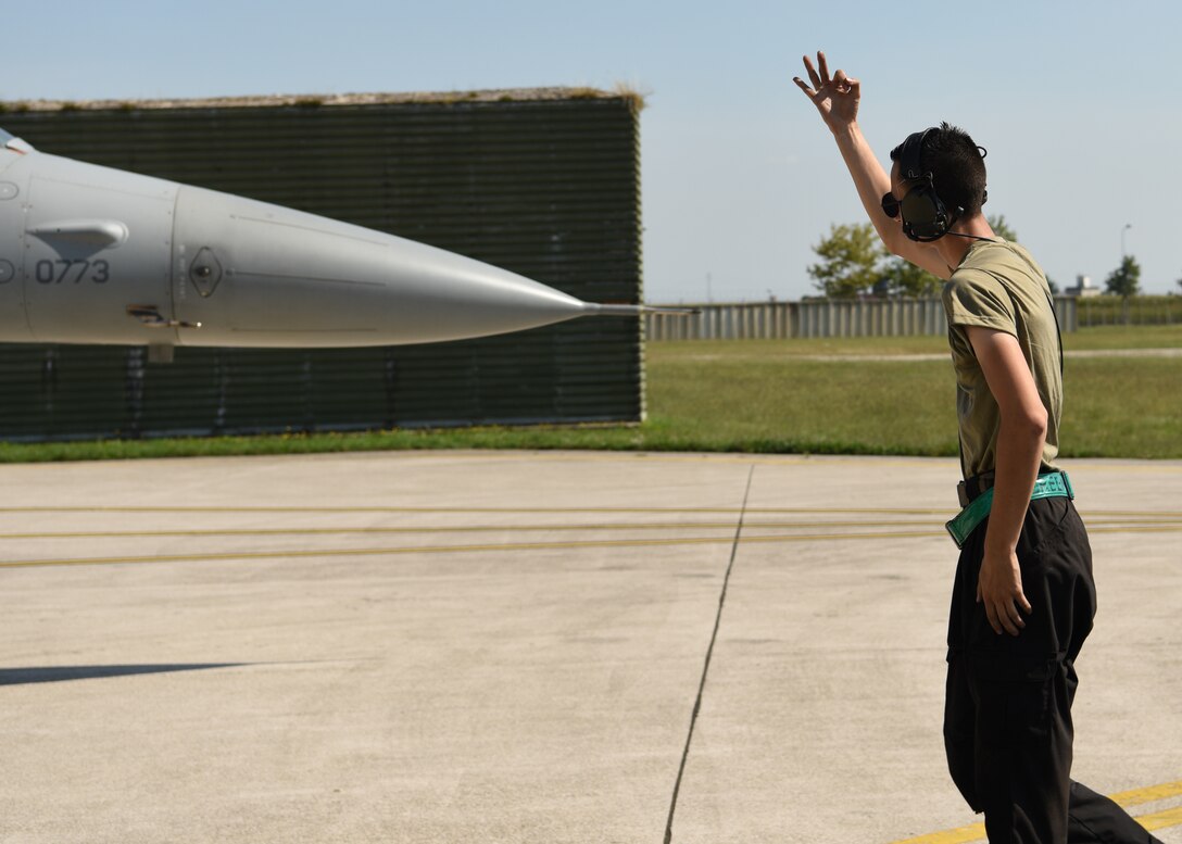 Senior Airman Cole McGriff, 555th Fighter Squadron crew chief, marshals a U.S. Air Force F-16 Fighting Falcon for exercise Point Blank 20-4 at Aviano Air Base, Italy, Sept. 10, 2020. Multilateral exercises like Point Blank increase interoperability and collective readiness. (U.S. Air Force photo by Staff Sgt. Heidi Goodsell)