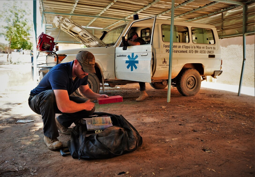 Staff Sgt. Jeffrey Urquhart, 724th Logistics Readiness Flight vehicle maintenance technician, services a local ambulance in Agadez City, Niger, Aug. 31, 2020. Volunteers were able to identify issues and make basic repairs to the ambulance, rendering the vehicle serviceable for use. The repairs came at a time when the city was recovering from significant flooding. (Courtesy Photo)