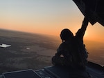 U.S. Army Staff Sgt. Brad Whitt, crew chief with Bravo Company, 2-104th General Support Aviation Battalion, 28th Expeditionary Combat Aviation Brigade, sits on a ramp and looks at the sunset out the back of a CH-47 Chinook helicopter as it flies over the 28th ECAB's mobilization station at Fort Hood, Texas.