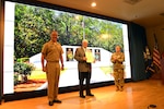 Chris Cherry (center), was recognized with the Department of the Navy Distinguished Public Service Award, by Rear Adm. Eric H. Ver Hage, EOD Executive Manager (left), and Brig. Gen. Heidi J. Hoyle, Commanding General of the Military Surface Deployment and Distribution Command (right), at the EOD Technology and Training Program Board at Naval Sea Systems Command Headquarters, September 11. (U.S. Navy photo/released)