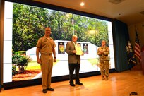 Chris Cherry (center), was recognized with the Department of the Navy Distinguished Public Service Award, by Rear Adm. Eric H. Ver Hage, EOD Executive Manager (left), and Brig. Gen. Heidi J. Hoyle, Commanding General of the Military Surface Deployment and Distribution Command (right), at the EOD Technology and Training Program Board at Naval Sea Systems Command Headquarters, September 11. (U.S. Navy photo/released)
