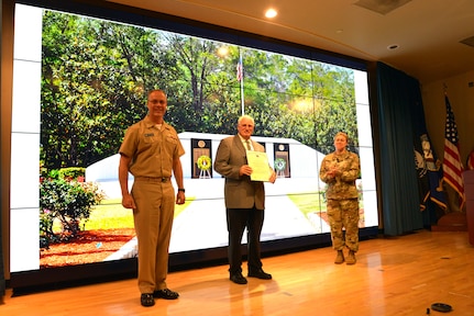 Chris Cherry (center), was recognized with the Department of the Navy Distinguished Public Service Award, by Rear Adm. Eric H. Ver Hage, EOD Executive Manager (left), and Brig. Gen. Heidi J. Hoyle, Commanding General of the Military Surface Deployment and Distribution Command (right), at the EOD Technology and Training Program Board at Naval Sea Systems Command Headquarters, September 11. (U.S. Navy photo/released)