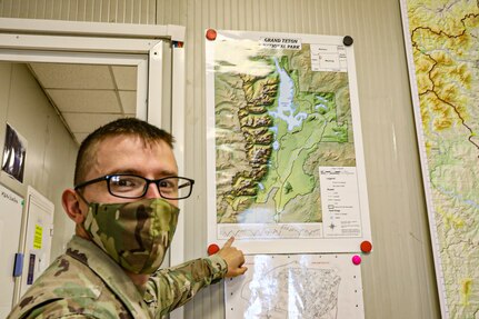 Spc. Caleb Kaufmann, a geospatial engineer with the 41st Infantry Brigade Combat Team, Oregon National Guard, deployed to the KFOR Regional Command East mission points to a map that he made using ArcGIS Sept.1, 2020, at Camp Film City Pristina/Prishtina,Kosovo.