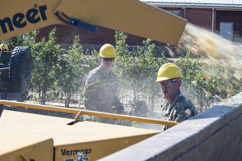 Utah Governor Gary Herbert stand with Soldiers at a debris waste collection site.