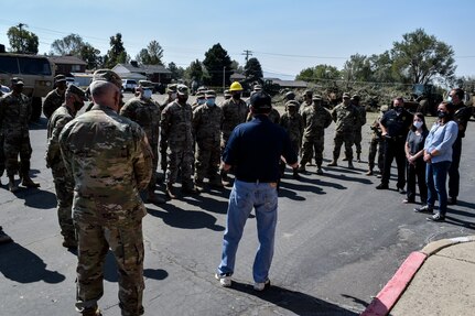 Utah Governor Gary Herbert stand with Soldiers at a debris waste collection site.