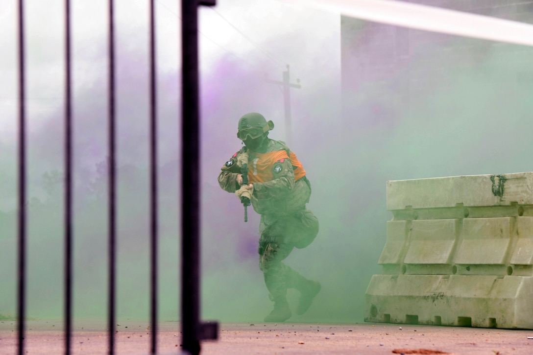 A guardsman holds a weapon while moving through a green cloud of smoke.