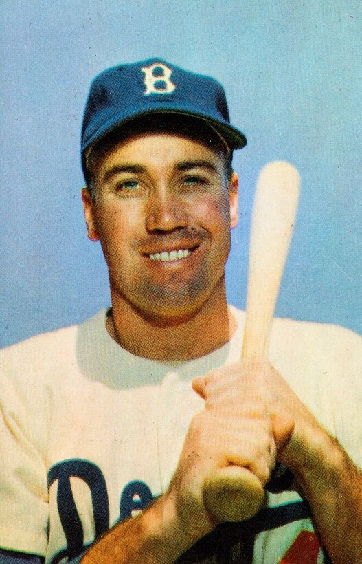 A baseball player poses for a photo with his bat over his shoulder.