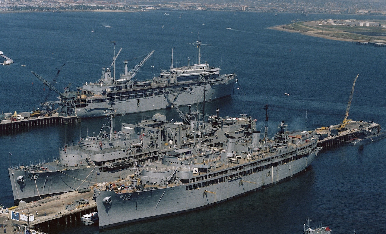 Large military ships docked in a blue waters.