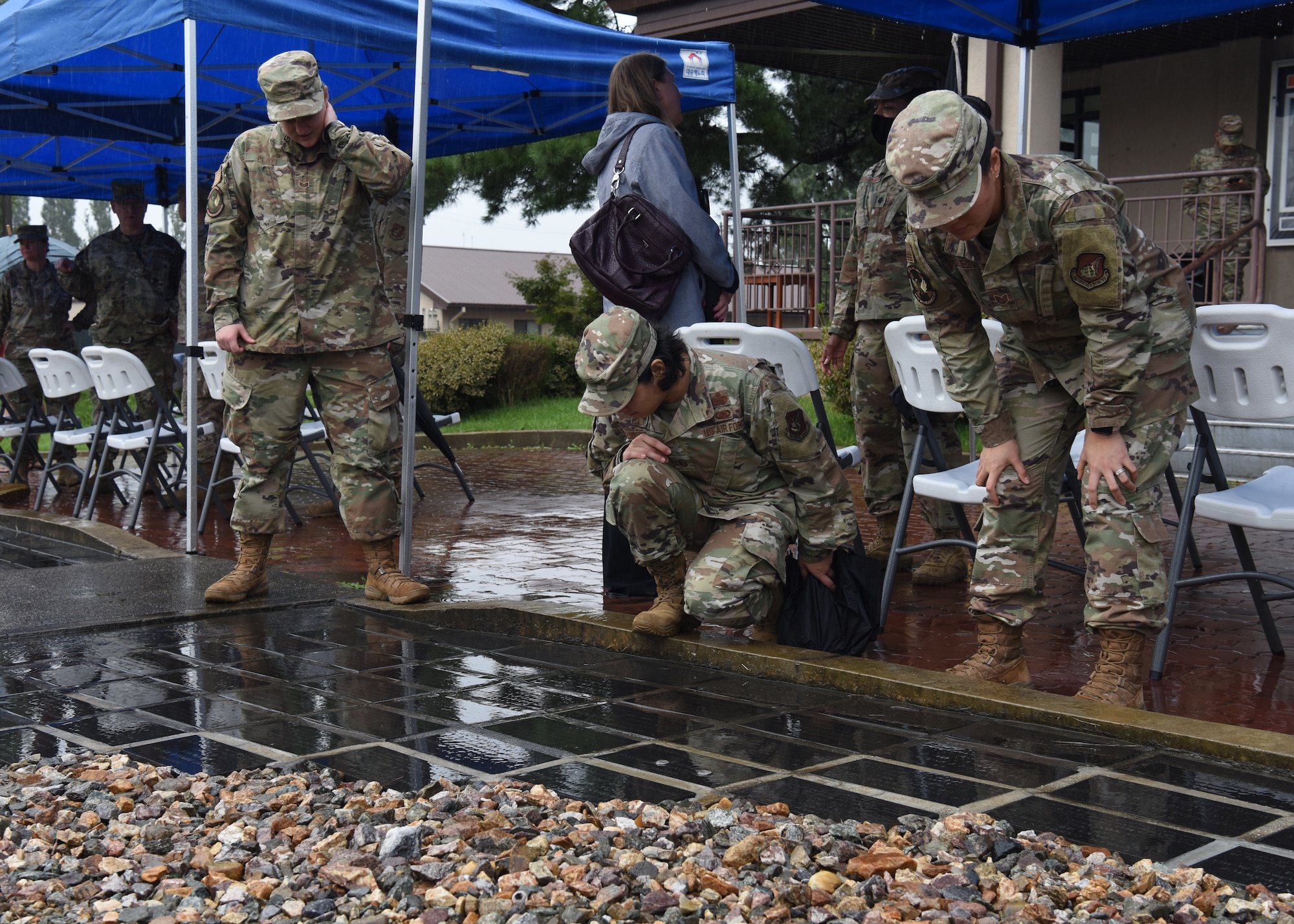 Ceremony participants look at commemorative bricks of a POW/MIA memorial during a POW/MIA Recognition Day ceremony at Osan Air Base, Republic of Korea, Sept. 16, 2020. Each brick has the name, unit and date the servicemember was declared POW/MIA during the Korean War, and serves as a reminder to passersby that they will never be forgotten. (U.S. Air Force photo by Senior Airman Denise Jenson)