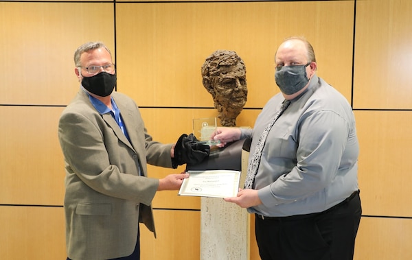 Terry S. Morgan, General Service Administration (GSA), Zorinsky Federal Building Manager presents the 2019 Federal Employee-Manager/Supervisor of the Year by the Lincoln Federal Executive Association Award to Lee McCormick, Civil Branch Chief, Contracting Division U.S. Army Corps of Engineers, Omaha District the for his work on the 2019 Flood Response (OSRT), July 2020.