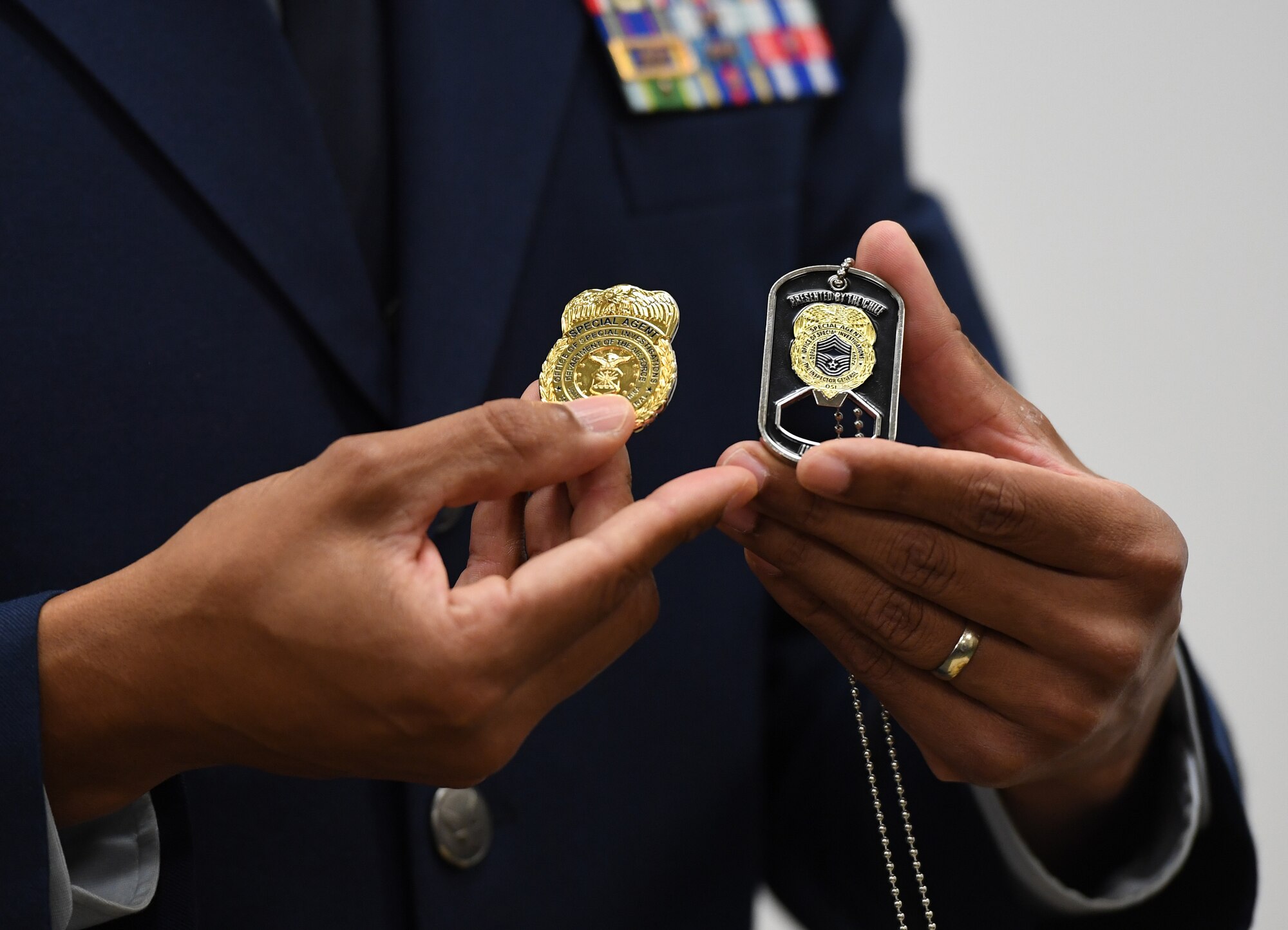 U.S. Air Force Special Agent Shannon Robinson, Air Force Office of Special Investigations Detachment 407 commander, holds mementos during a presentation ceremony inside the Levitow Training Support Facility at Keesler Air Force Base, Mississippi, Sept. 11, 2020. Airman Joshua Balmer, 737th Training Group basic military training graduate and son of fallen OSI Special Agent Ryan Balmer, was presented mementos by the detachment following his graduation from BMT. (U.S. Air Force photo by Kemberly Groue)