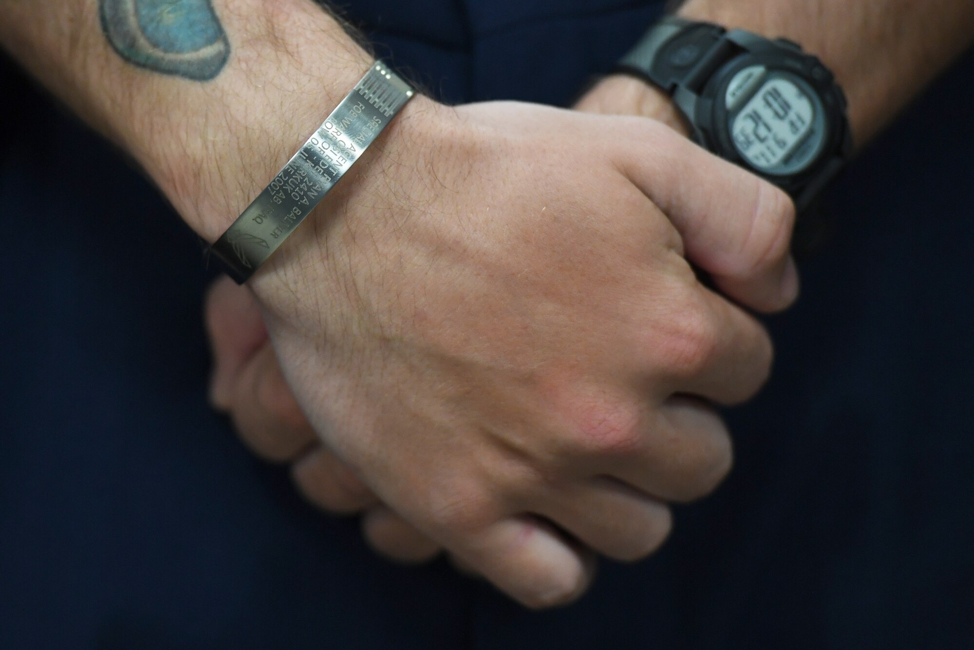 U.S. Air Force Airman Joshua Balmer, 737th Training Group basic military training graduate, wears a memorial bracelet during a presentation ceremony inside the Levitow Training Support Facility at Keesler Air Force Base, Mississippi, Sept. 11, 2020. Balmer, son of fallen Air Force Office of Special Investigations Special Agent Ryan Balmer, was presented mementos by the AFOSI Detachment 407 following his graduation from BMT. (U.S. Air Force photo by Kemberly Groue)